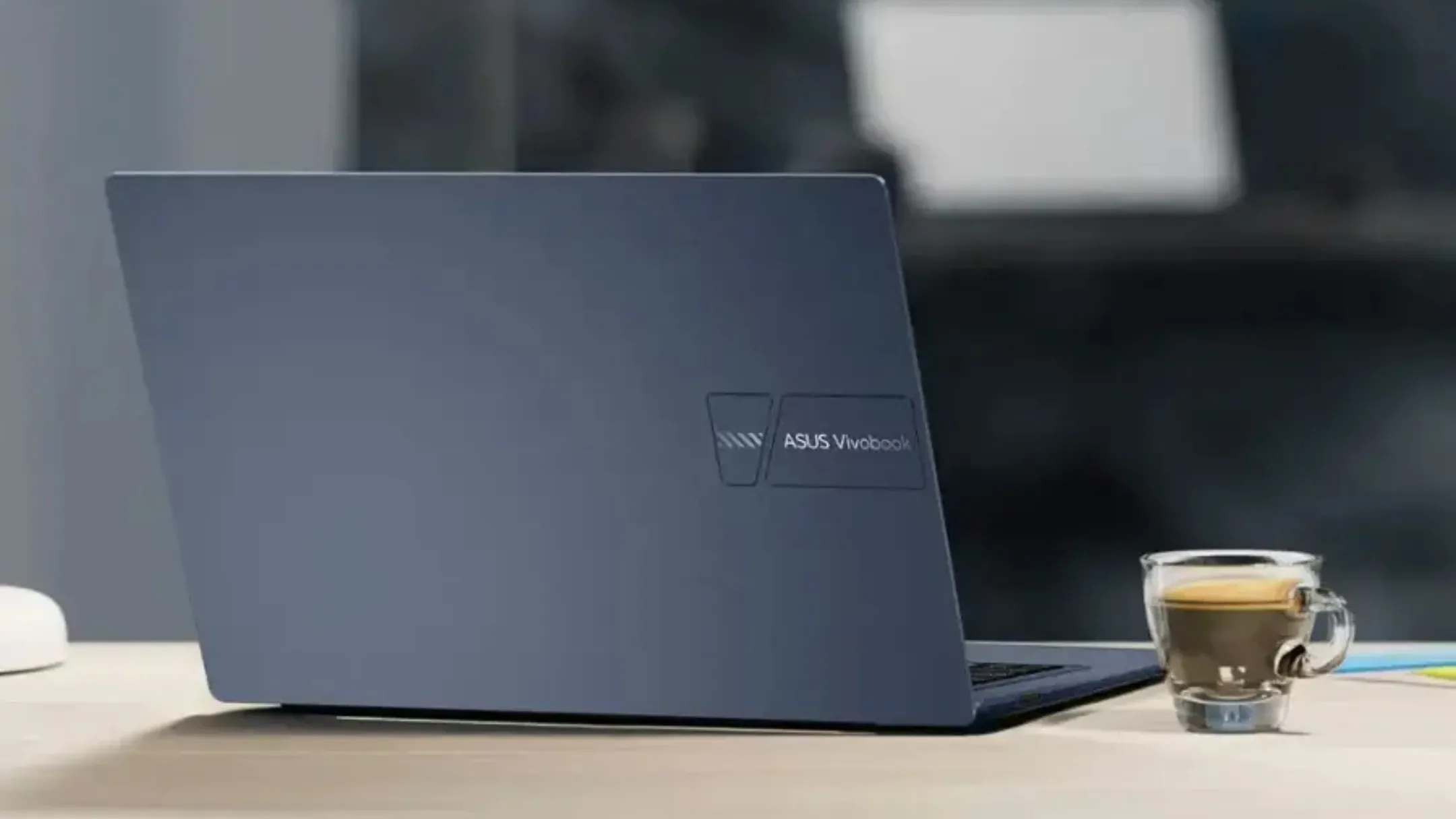 Asus Vivobook 14 trên bàn làm việc bằng gỗ, cho thấy tính di động và phù hợp với môi trường học tập, văn phòng nhẹ nhàng.