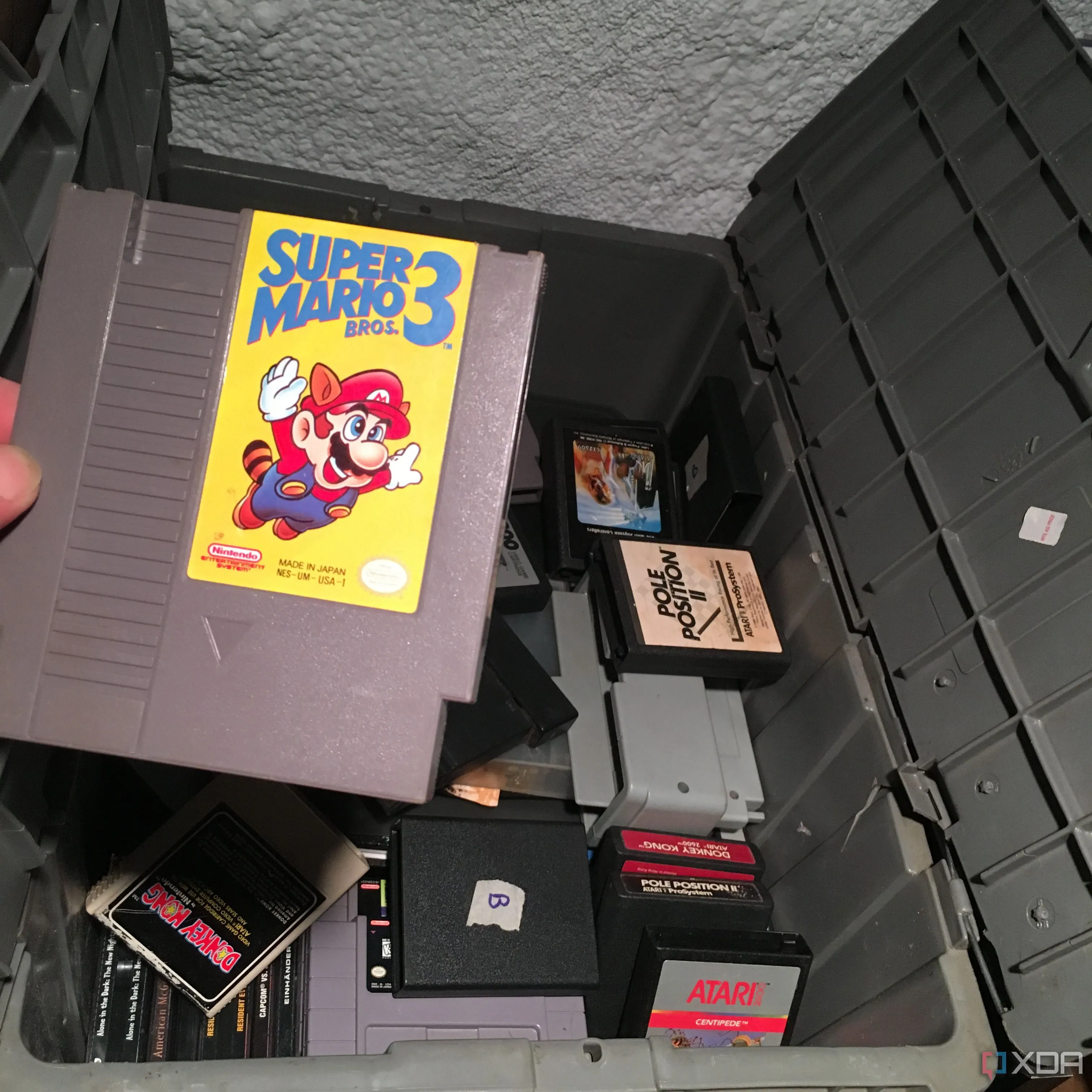 Băng game Super Mario Bros 3 NES được lấy ra từ hộp đựng game retro cũ, gợi nhớ kỷ niệm về game cổ điển.