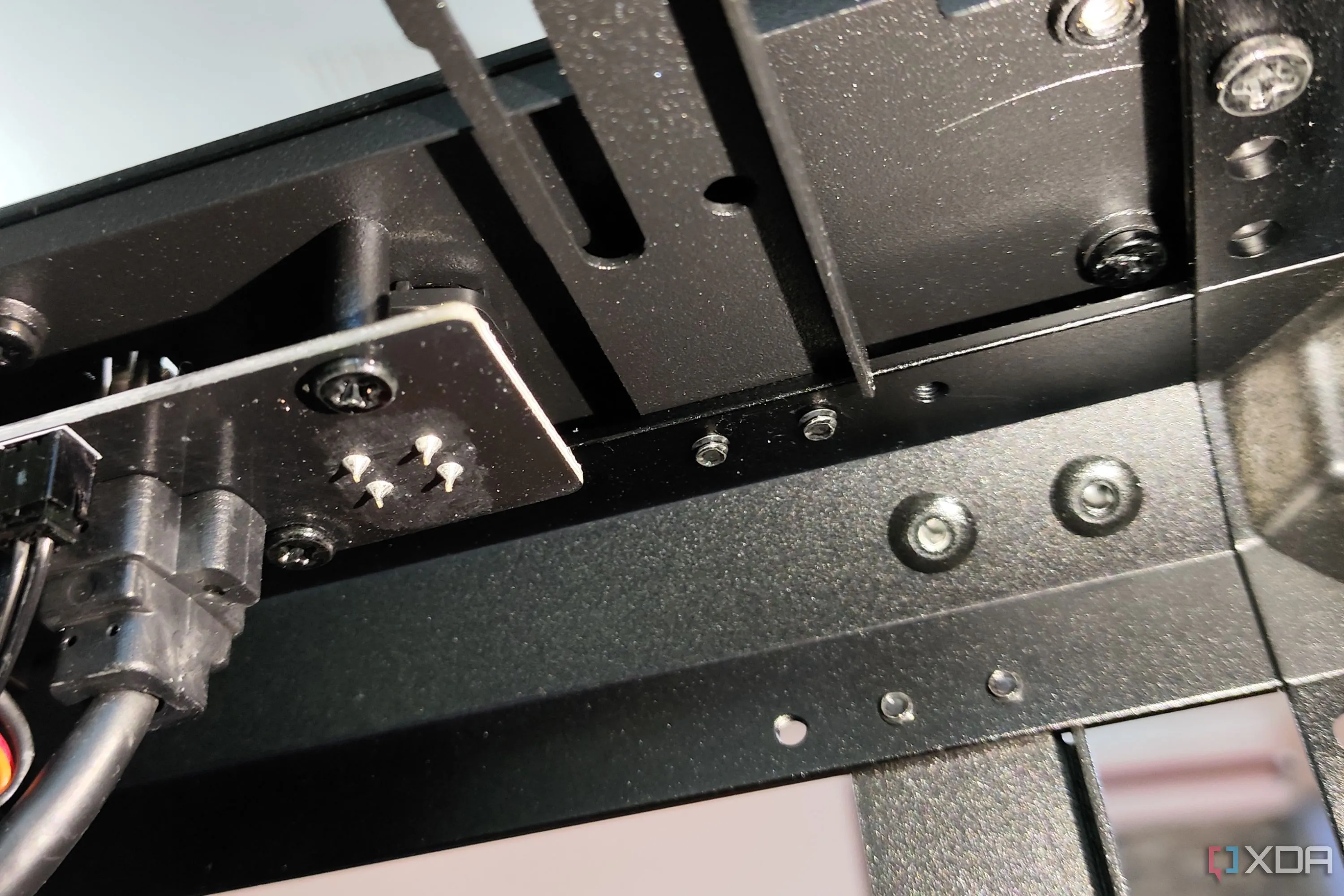 Hình ảnh cận cảnh các ốc vít khó tiếp cận nằm sâu dưới khu vực cổng I/O phía trước của MasterFrame 600, gây khó khăn cho việc tùy chỉnh vỏ case