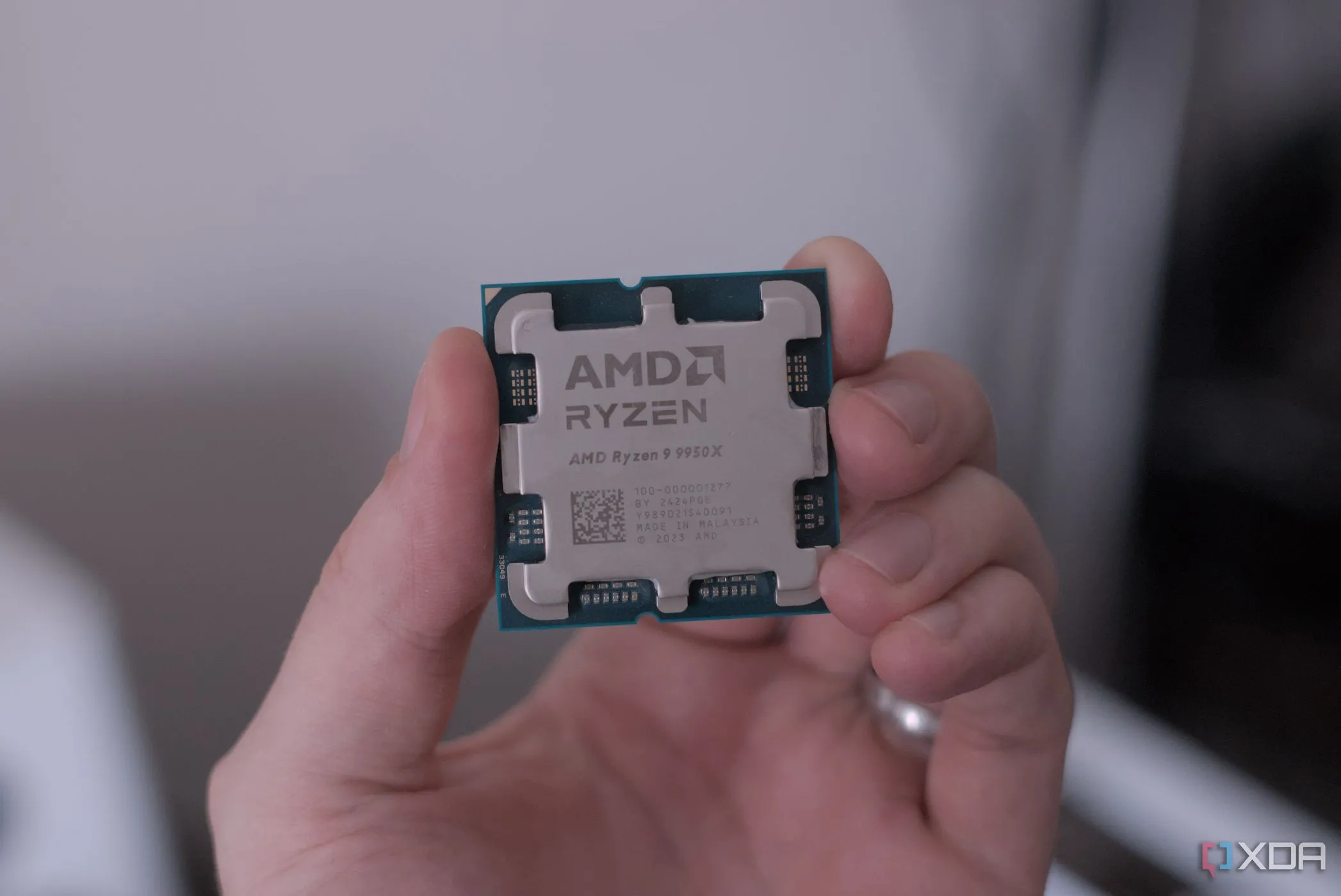 Hình ảnh cận cảnh một CPU AMD Ryzen 9 9950X đang được cầm trên tay, minh họa cho việc tối ưu hiệu năng và giảm nhiệt độ bằng cách undervolt linh kiện máy tính.