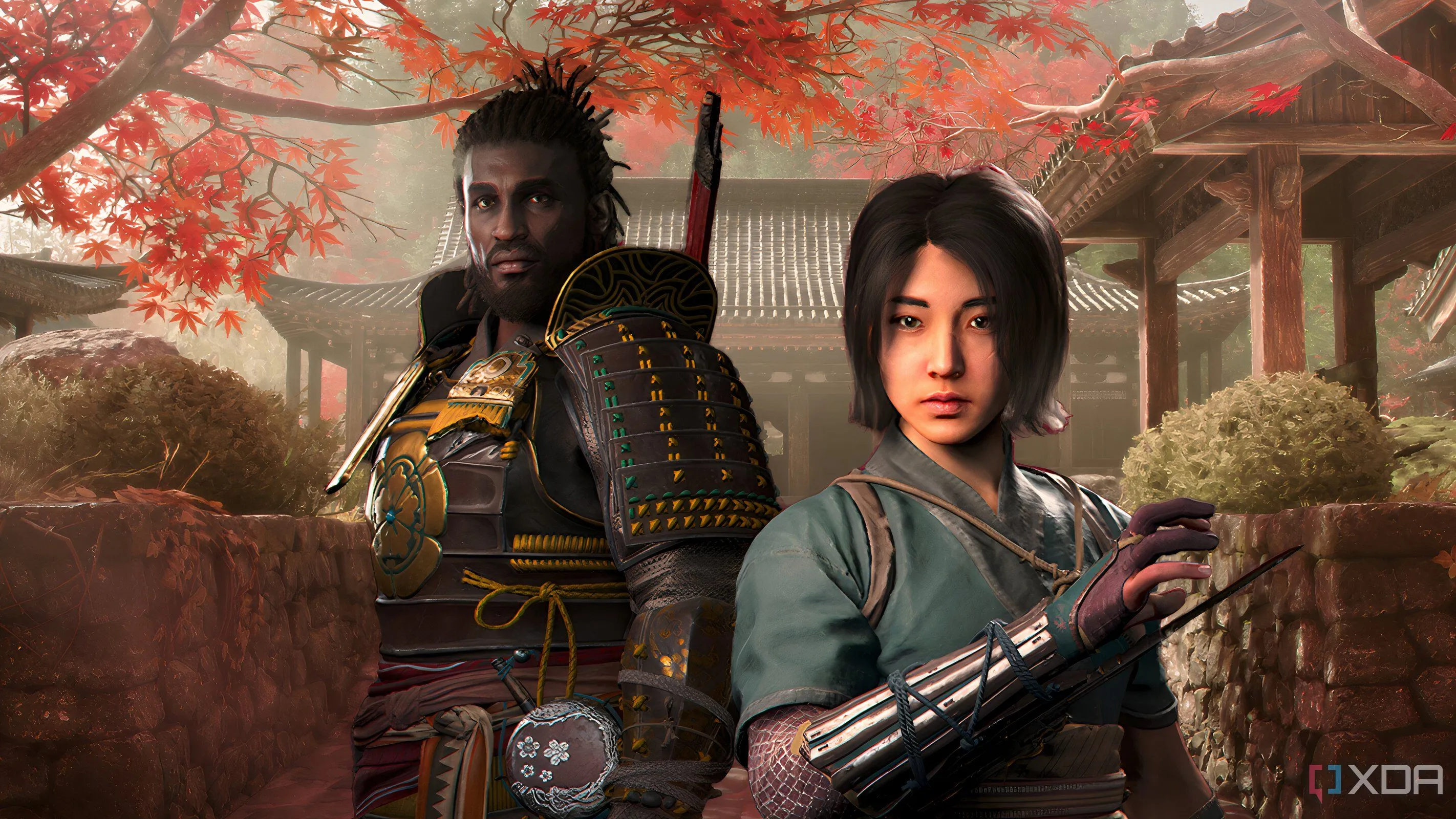 Hình ảnh Naoe và Yasuke đứng trước hàng cây lá đỏ và kiến trúc Nhật Bản truyền thống trong Assassin's Creed Shadows, thể hiện sự đa dạng lối chơi của hai nhân vật.