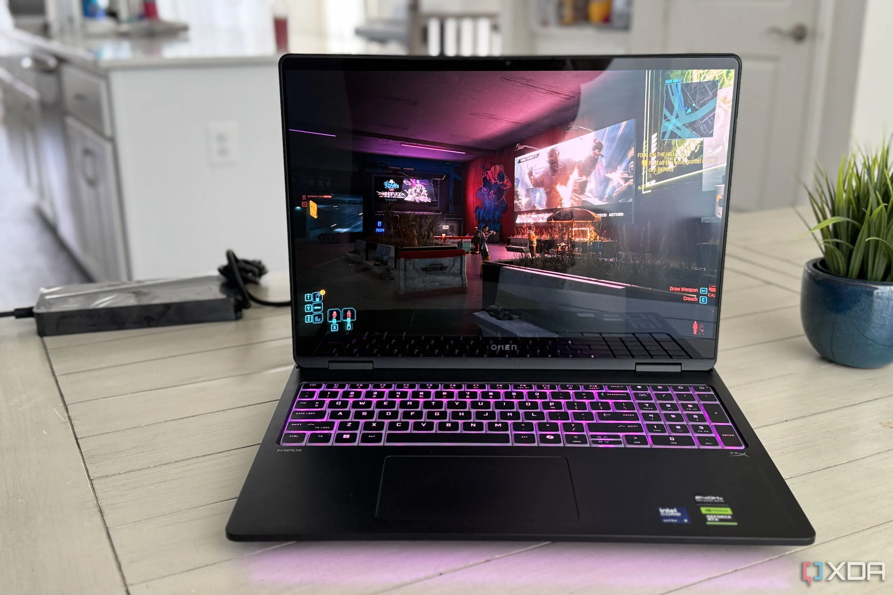 Laptop HP Omen Max 16 đang cắm sạc khi chơi game Cyberpunk, nhấn mạnh sự phụ thuộc vào nguồn điện để đạt hiệu suất cao nhất.