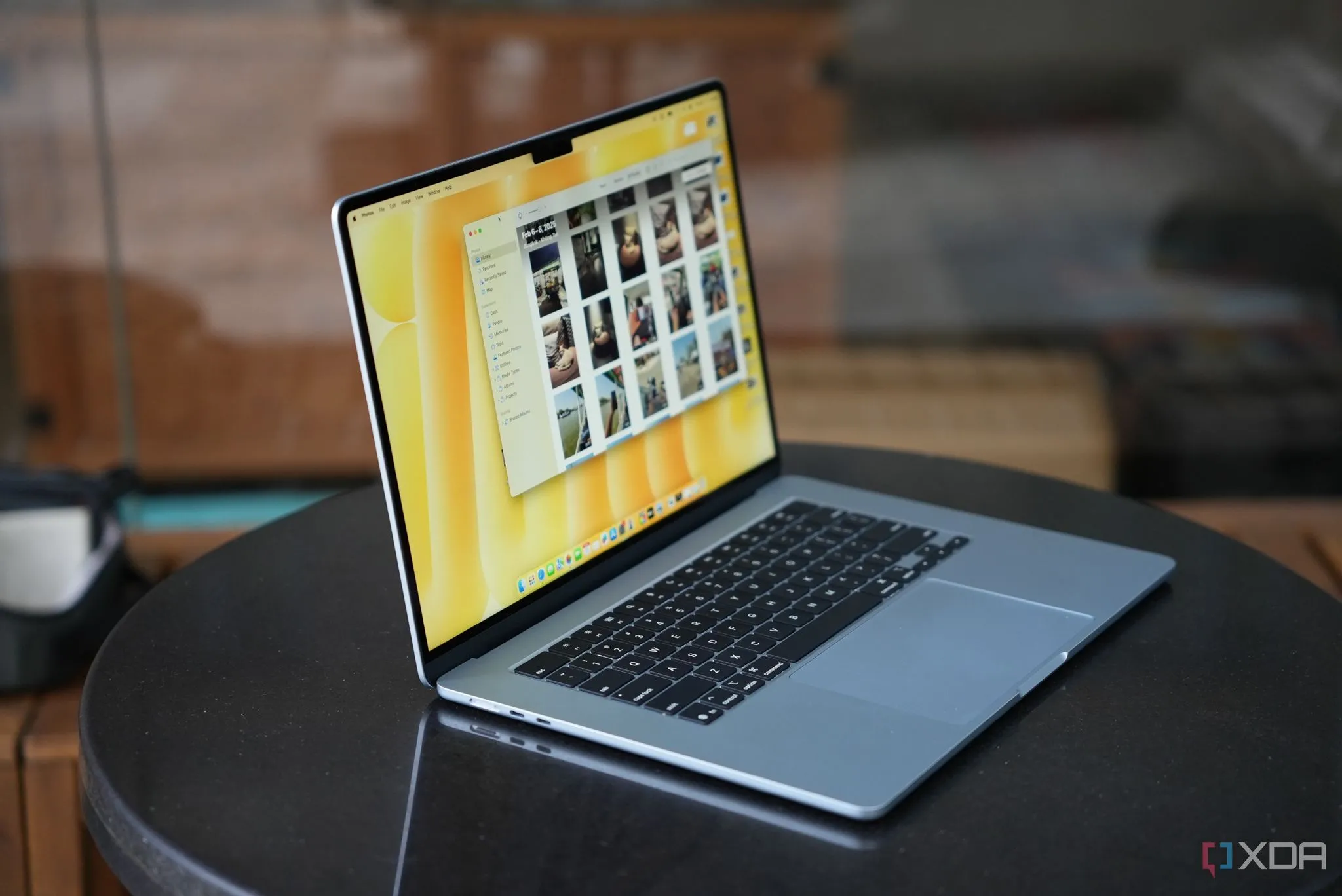 Laptop MacBook Air M4 màu đen trên bàn làm việc cùng với điện thoại iPhone và cốc cà phê