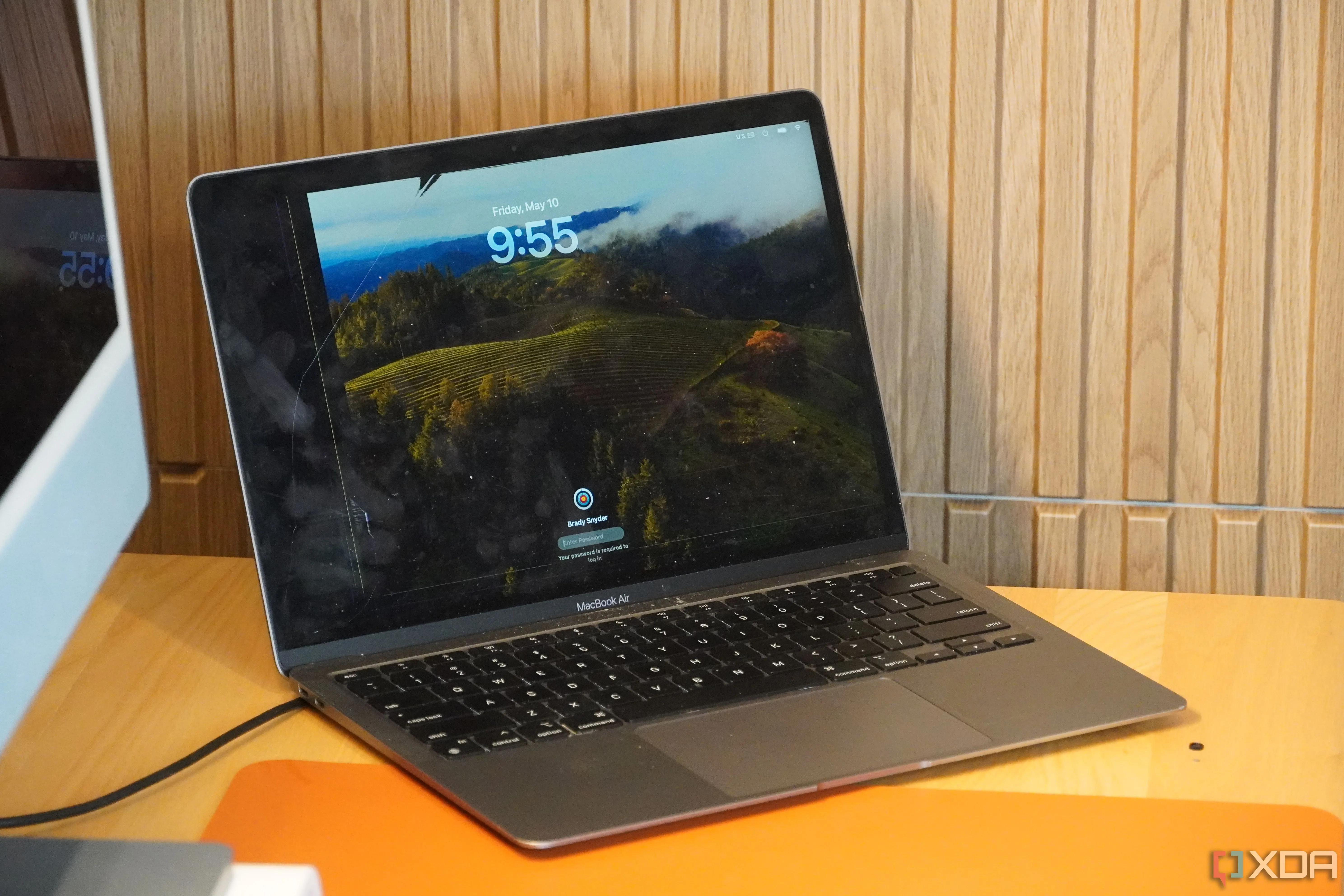 Màn hình MacBook bị nứt đặt trên bàn làm việc, minh họa chi phí sửa chữa cao