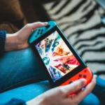 Máy chơi game Nintendo Switch được cầm trên tay, màn hình có thể đang hiển thị lỗi hoặc giao diện thử nghiệm.