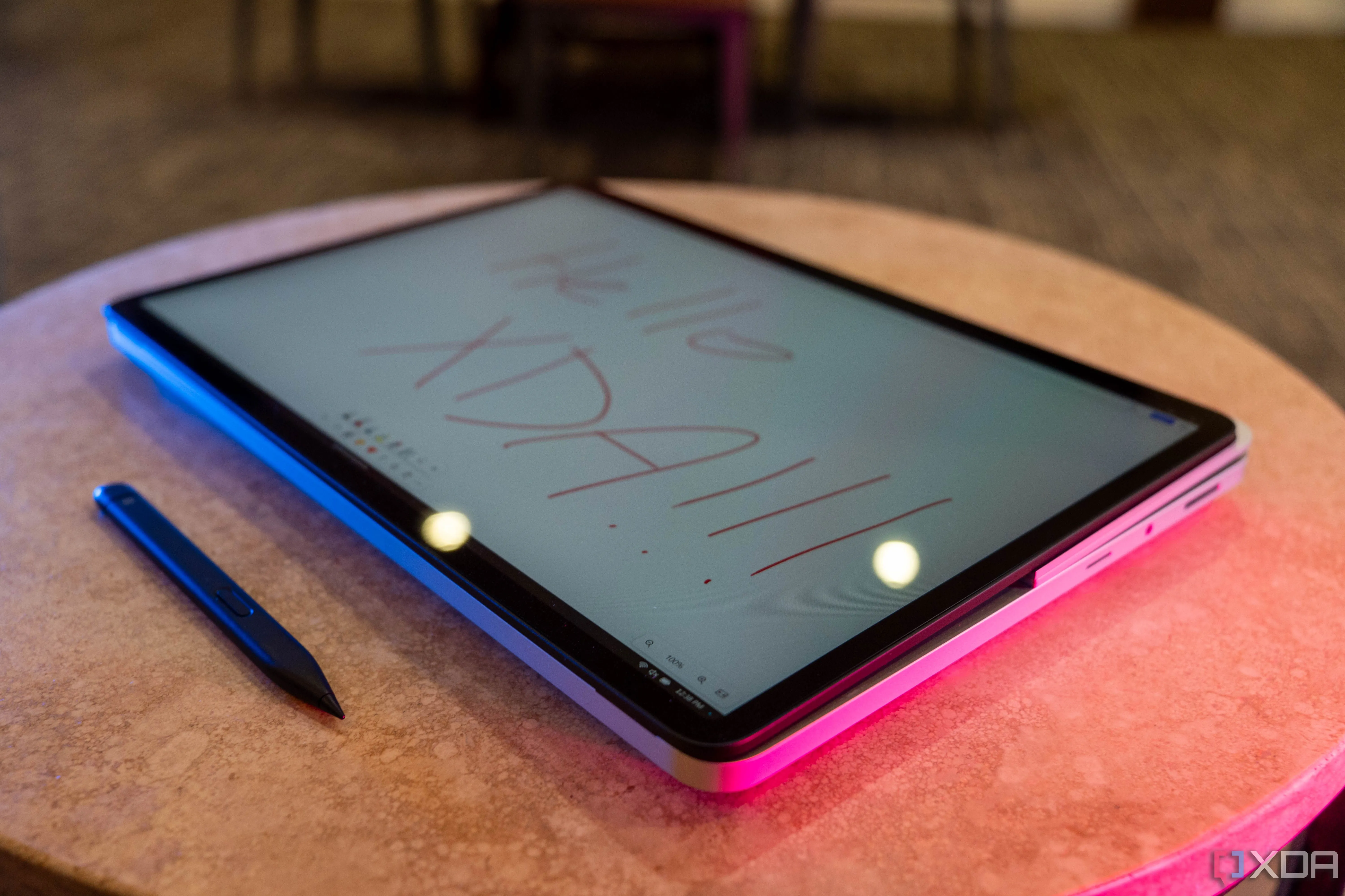 Máy tính xách tay Surface Laptop Studio 2 ở chế độ tablet với bút cảm ứng và dòng chữ Hello XDA trên màn hình
