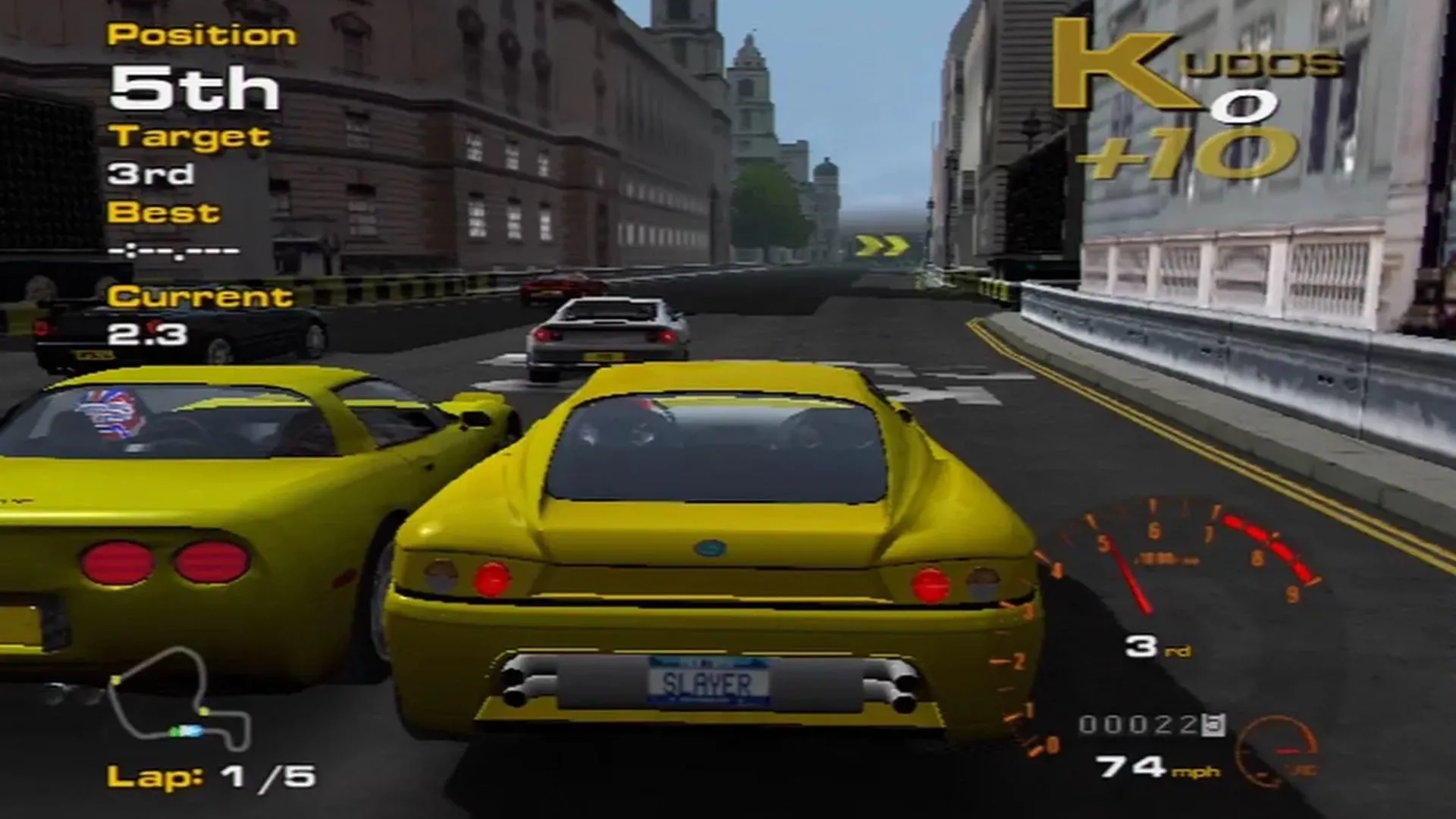 Một ảnh chụp màn hình gameplay từ Project Gotham Racing với góc nhìn từ phía sau chiếc xe màu đỏ trên đường đua đô thị.
