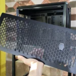 Một người đang cầm tấm panel phía trước của vỏ case Cooler Master MasterFrame 600 cho thấy thiết kế có thể tháo rời