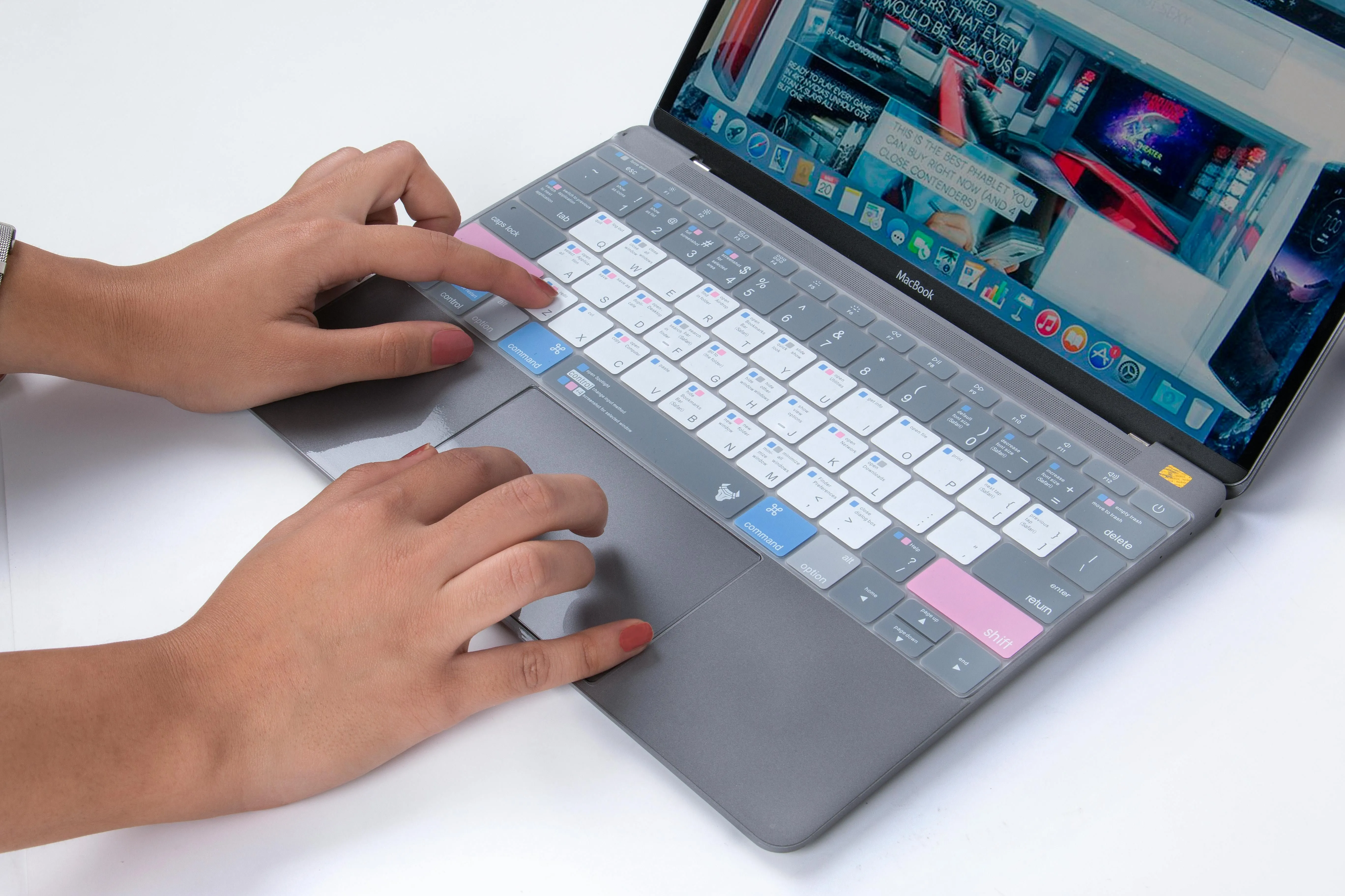 Người dùng đang gõ phím trên MacBook có miếng phủ bàn phím màu đen, cho thấy ảnh hưởng tiềm ẩn đến trải nghiệm gõ và màn hình.