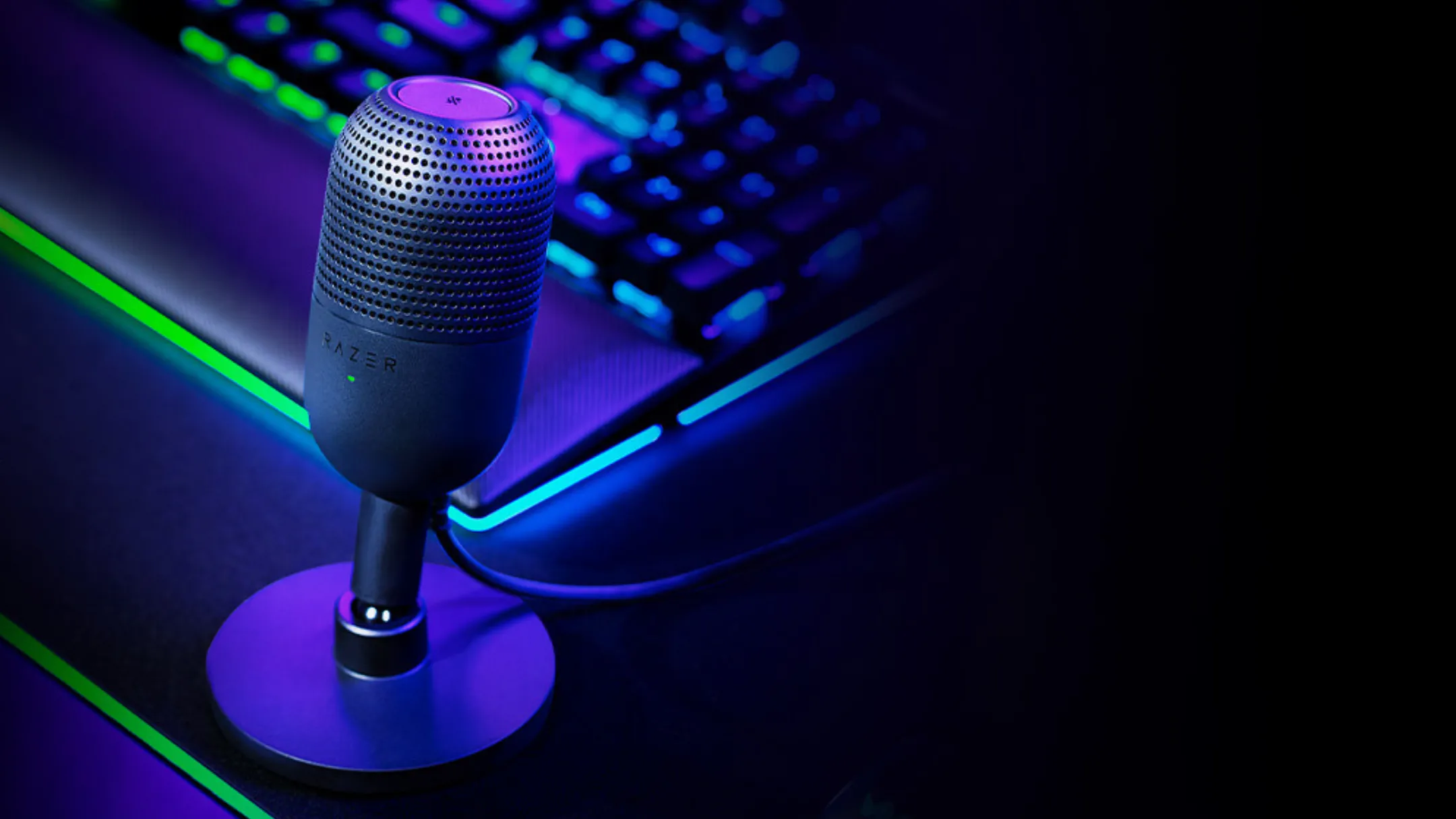 Razer Seiren V3 Mini đặt cạnh bàn phím cơ trên bàn làm việc