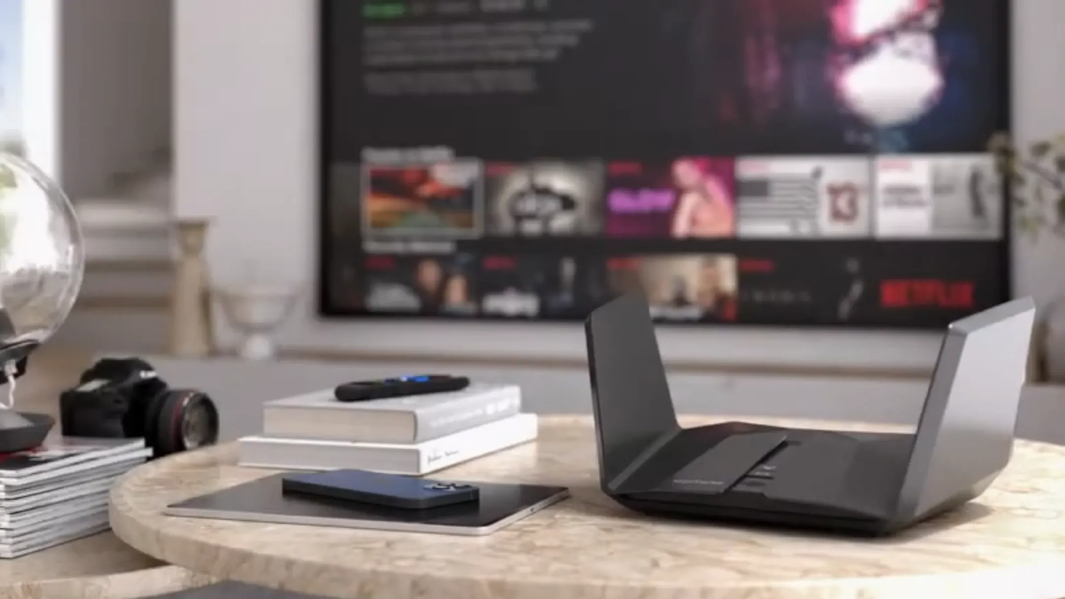 Router Netgear Nighthawk RAXE500 màu đen đặt trên bàn, biểu tượng cho khả năng kết nối WiFi siêu tốc