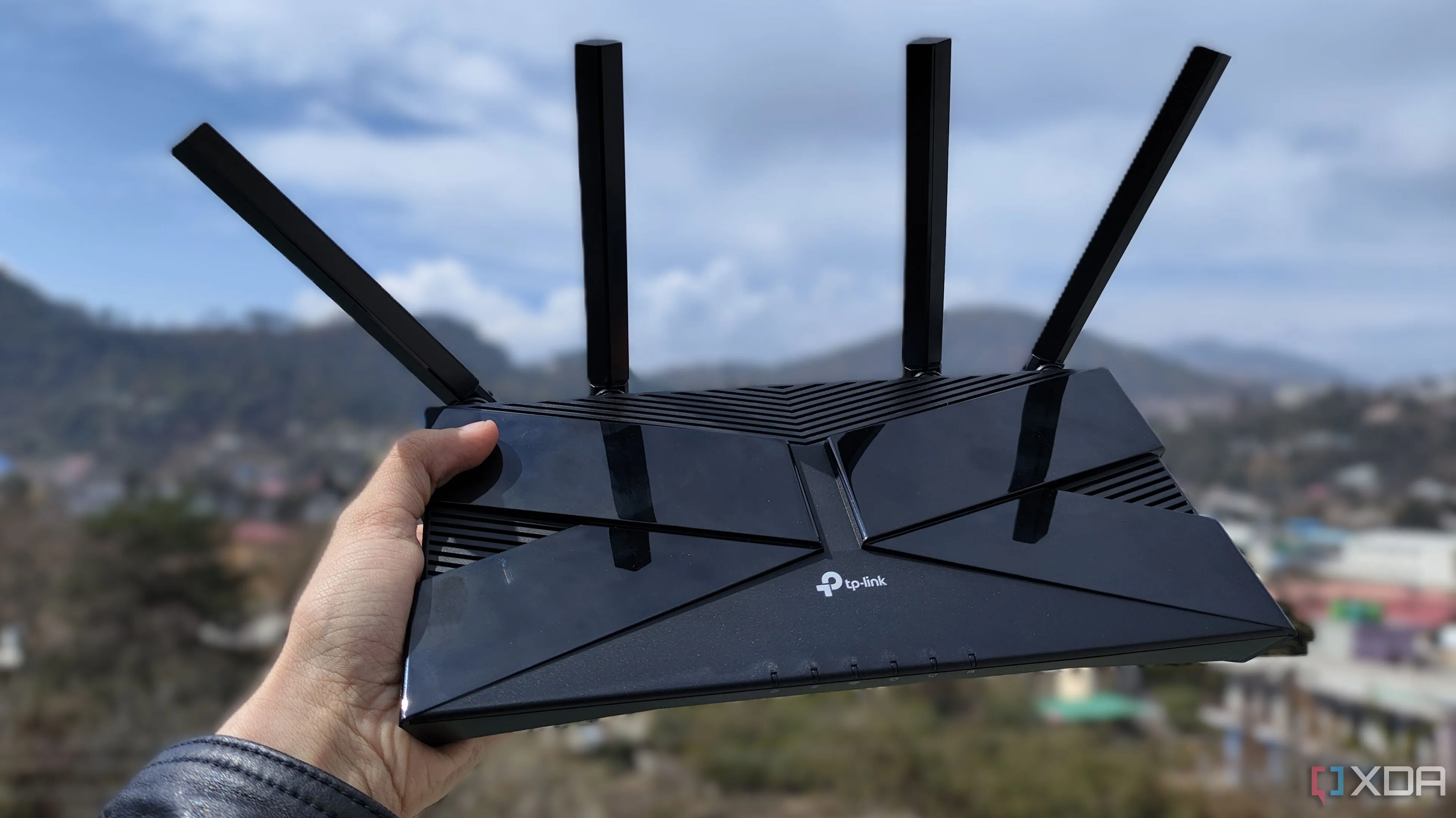 Router TP-Link được cầm trên tay để minh họa việc cấu hình mạng