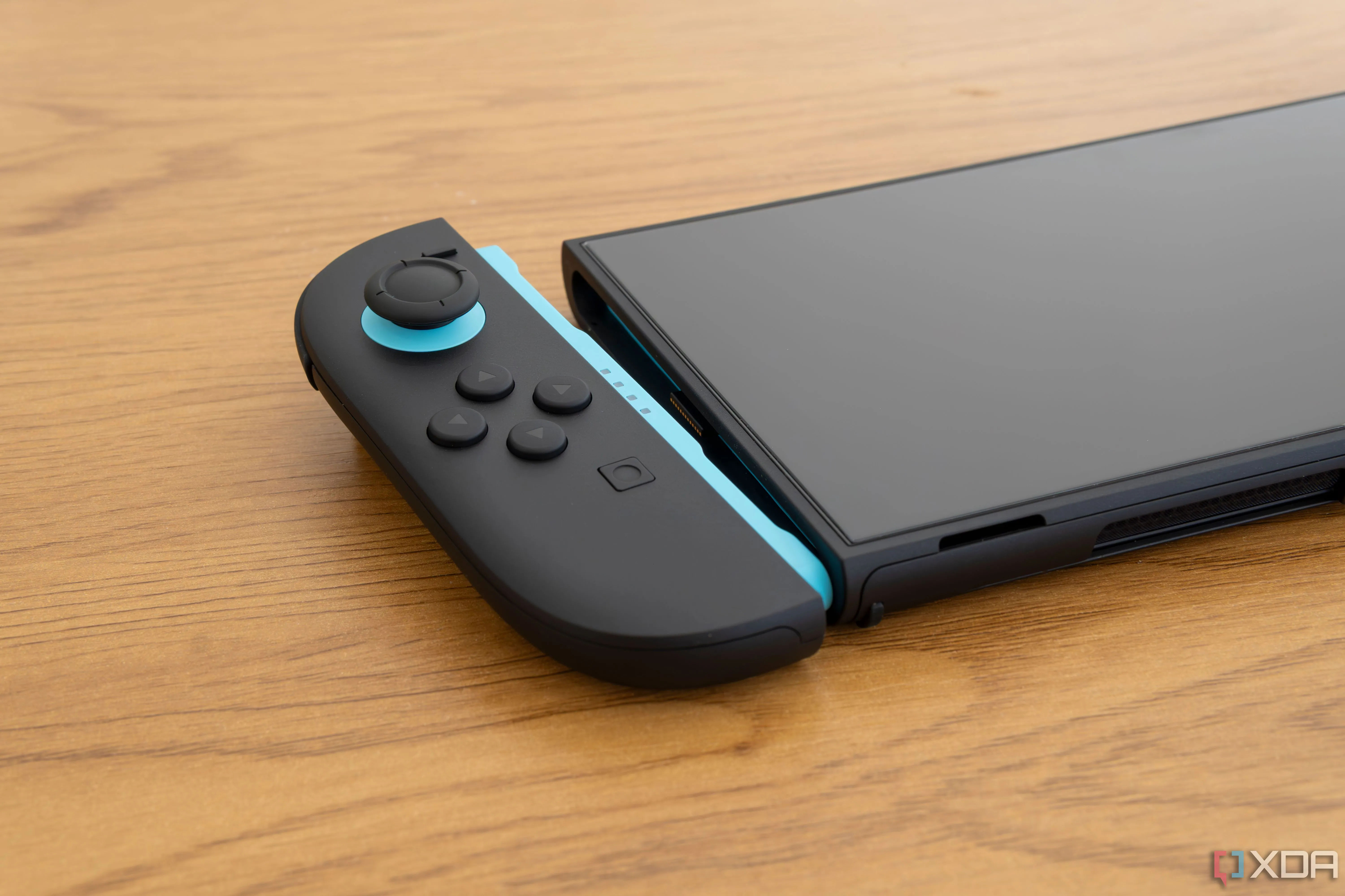 Tay cầm Joy-Con 2 màu xanh và đỏ tháo rời, đặt cạnh khe cắm tương ứng trên thân máy Nintendo Switch 2, thể hiện thiết kế module và khả năng chơi cầm tay.