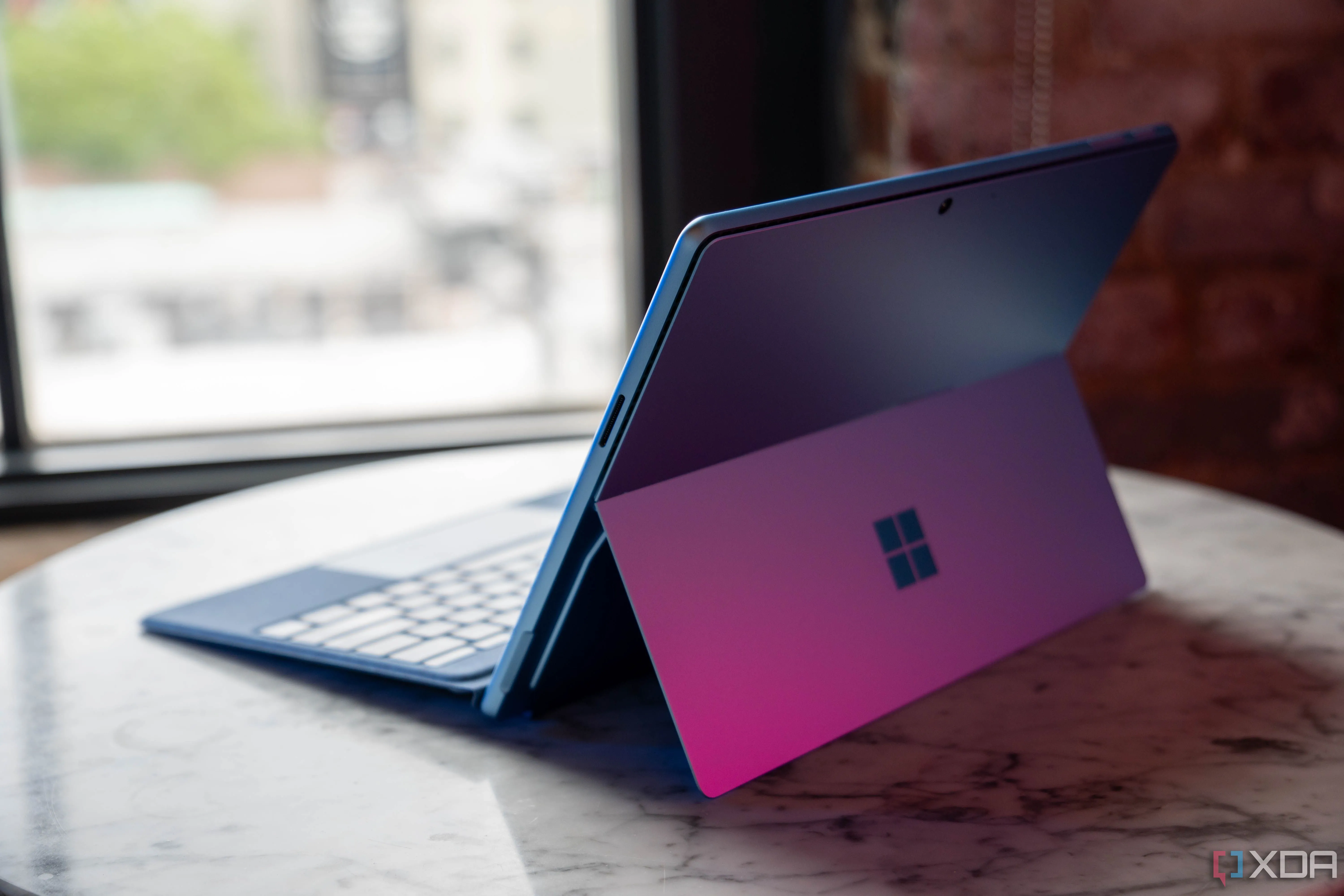 Thiết bị Microsoft Surface Pro 11 màu đen đặt cạnh hộp sản phẩm, minh họa đóng gói mới không kèm sạc do Chỉ thị Thiết bị Vô tuyến 2022 của EU.