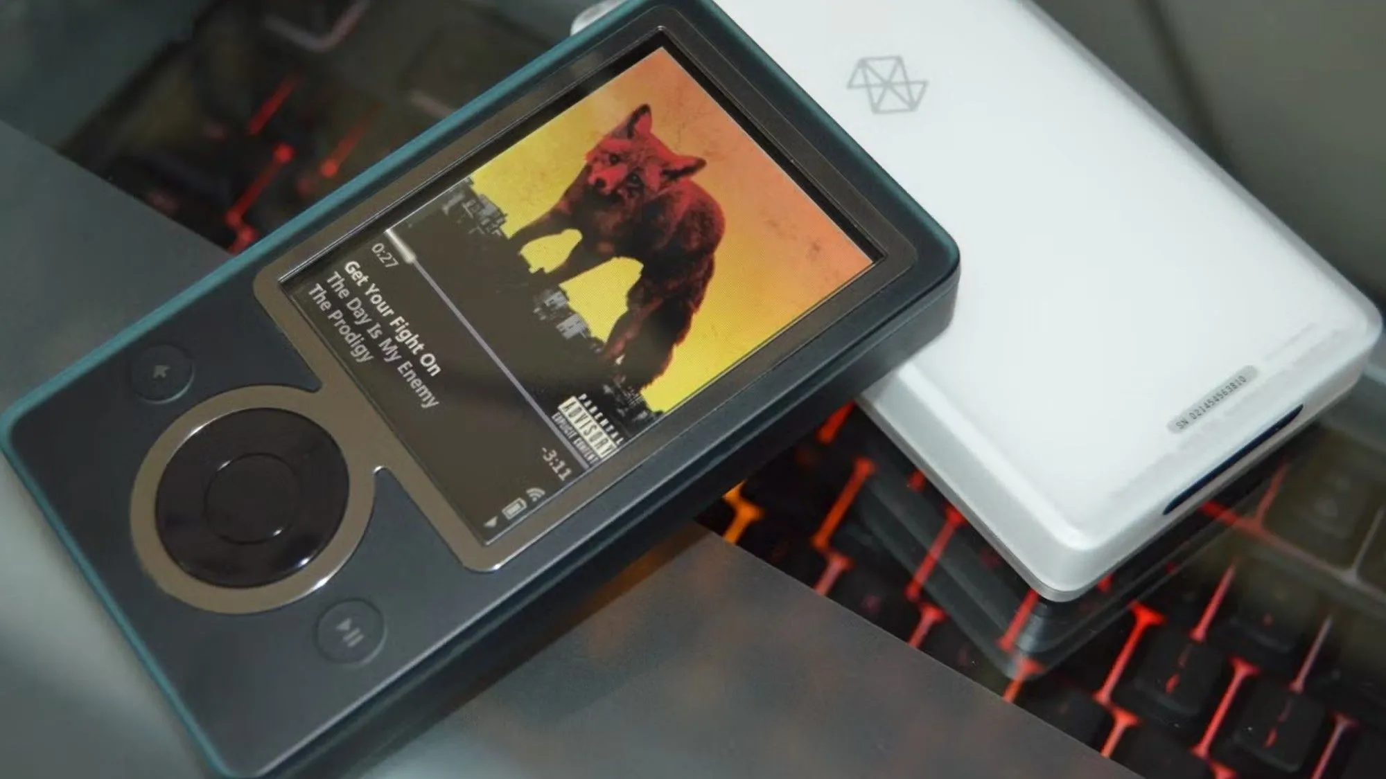 Thiết bị nghe nhạc Zune 30 màu đen đang hiển thị giao diện phát nhạc, đại diện cho kỷ nguyên Microsoft chú trọng vào dịch vụ giải trí cá nhân như Zune Video trước đây.